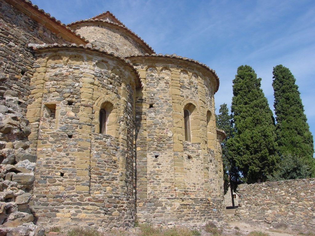La imatge mostra l'exterior del presbiteri format per tres absis circulars. El temple és d'estil romànic benedictí i per la decoració dels absis amb els nervis i les dobles arcuacions es diu que es de tradició llombarda. És un temple molt important pels objectes artístics que s'hi van trobar com també perquè conté un dels pocs frescos d'època romànica conservats in situ.