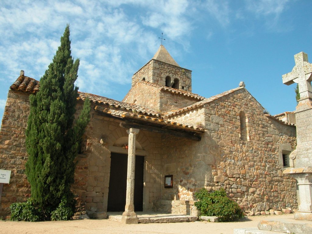 A la imatge es veu l'entrada de l'església de Sant Martí de Romanyà, aquesta està situada en un lateral i consta d'un petit pòrtic. El temple actual és una suma d'elements de diferents èpoques, l'església primitiva data del segle X i XI, la planta és de creu grega i en destaca el campanar amb elements del romànic ple amb finestres geminades i d'un pis. El coronament piramidal que es veu a la imatge va ser afegit en època moderna.
