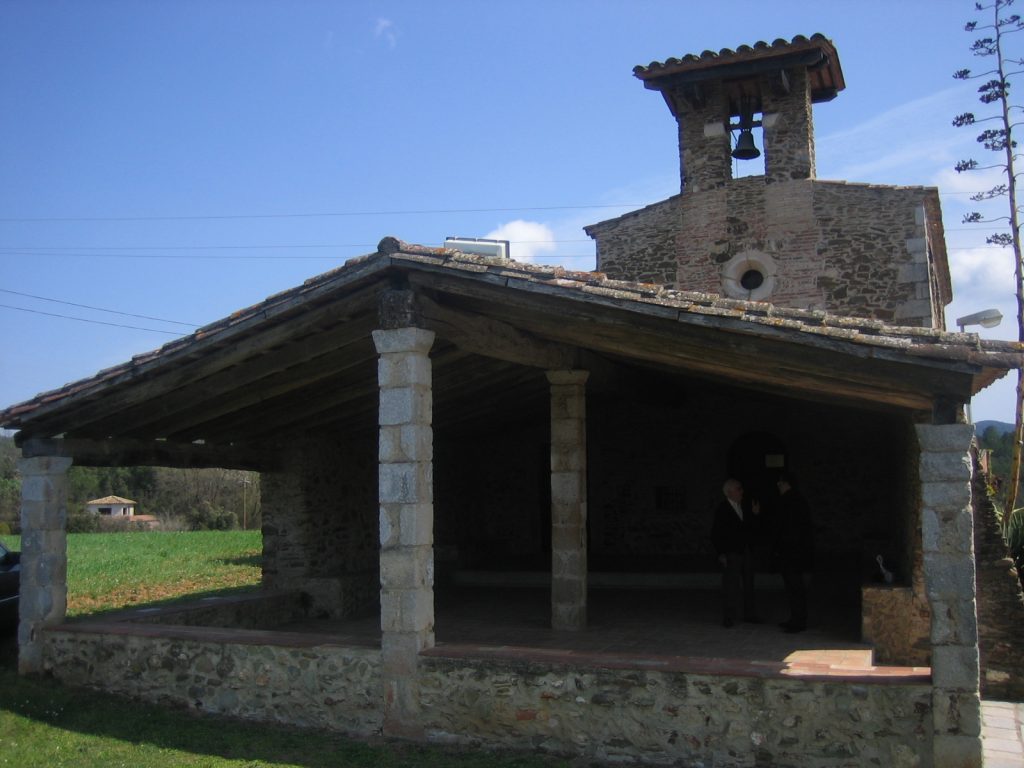 A l'ermita d'Erols en destaca el pòrtic que fa 90 m2. Els orígens de l'església son del segle XII, es va restaurar en diverses ocasions, l'última al 1979 que li donà l'aspecte actual. En la fotografia en destaca el porxo i darrera seu sobresut la façana de l'ermita amb la rosassa i el campanar de cadireta.