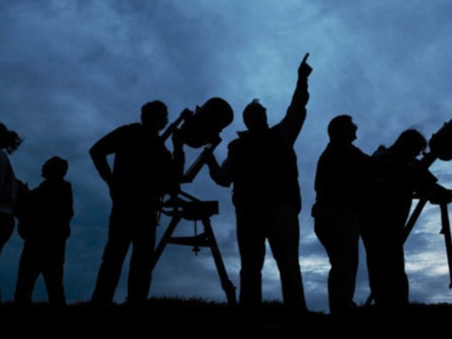 Grup de persones observant el cel.
